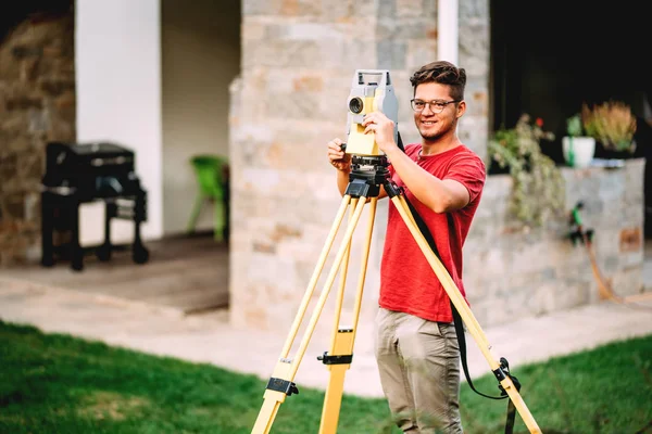 Vermessungstechniker arbeitet mit Totalstation Theodolit bei Landschaftspflegeprojekt — Stockfoto