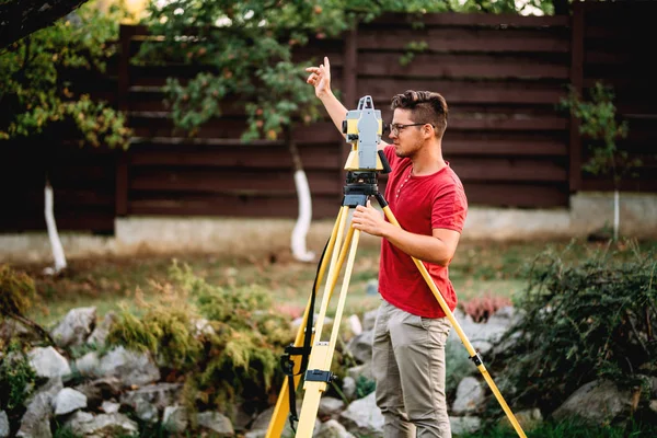 Ingénieur d'arpentage dans le chantier de construction d'élévation de jardin utilisant et travaillant avec la théodolite — Photo