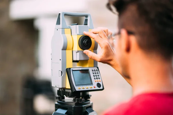 Close up details of survey engineer using and working with total station theodolite at landscaping project — Stock Photo, Image