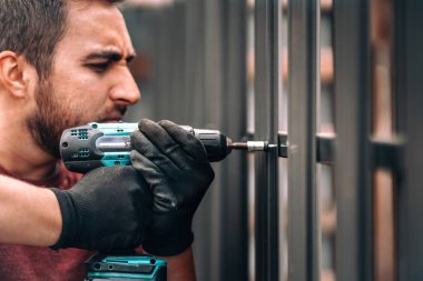 Metal elementler için kablosuz tornavida kullanan inşaat işçisi