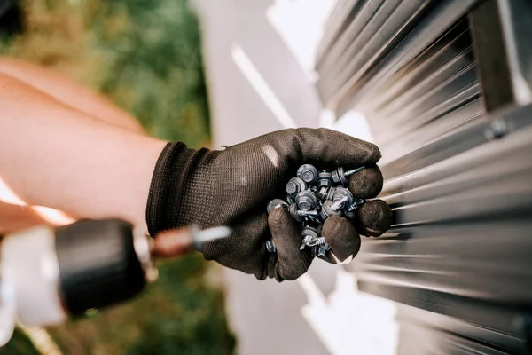 Worker working screws and electric screwdriver on the construction site — Stock Photo, Image