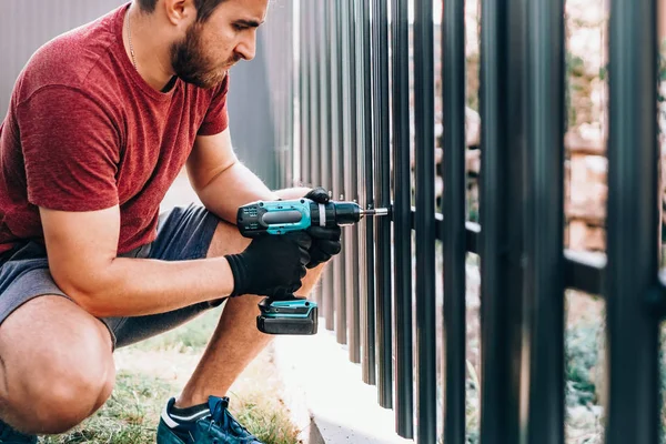 Werknemer werkt met een elektrische schroevendraaier op de bouwplaats — Stockfoto