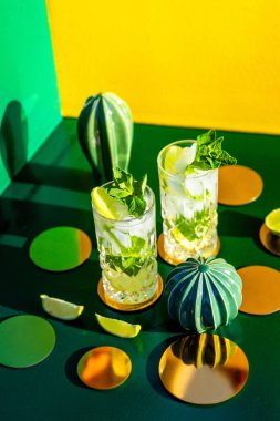Barda ya da barda alkollü içecek ve içeceklerle ilgili detaylar renkli arkaplanda buzlu mojito. Üst görünüm
