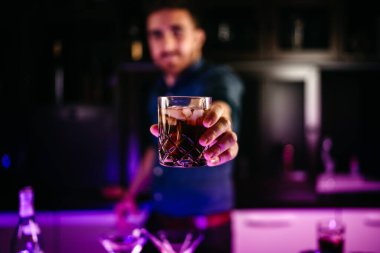 Barmenin portresi tezgahta kahverengi rom, kola ve limonla taze Küba libresi hazırlıyor.