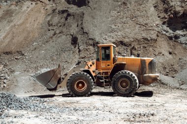 Maden ocağındaki endüstriyel makineler, taş ve çakıl taşıyan ağır kazıcılar. Ayrıntıları kapat