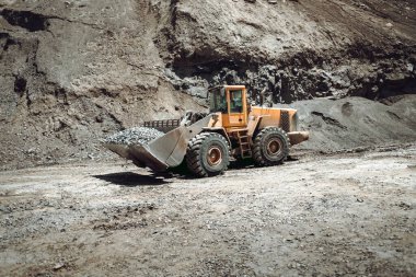 Çakıl taşıma ve çöp kamyonu yükleme alanındaki ağır inşaat makineleri