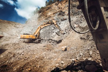 Madencilik ve inşaat endüstrisi - Parça tipi kazıcı granit kaya veya cevheri ezme ve tasnif tesisinde yüklüyor
