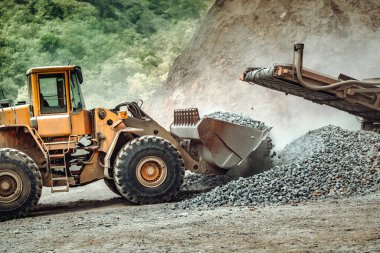 Endüstriyel tekerlek yükleyici çalışıyor. Tekerlek yükleyiciyi kapat, çalışıyor, çakıl boşaltılıyor 
