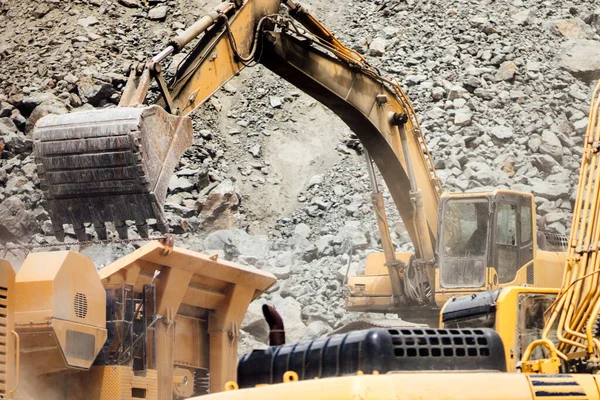 在工地及堆石机上工作的工业挖掘机详情 — 图库照片