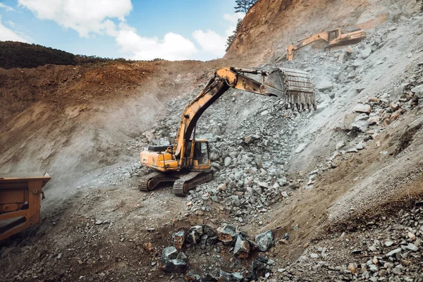 采石场或建筑工地堆放卡车上的工业履带式挖掘机挖掘及装载矿石的详情 机械详情 — 图库照片