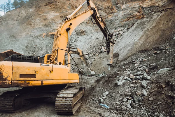 采石场或建筑工地垃圾车中工业挖掘机挖掘和装载矿石的详细情况 — 图库照片