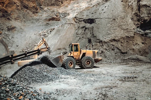 Industrial machinery on ore quarry site, heavy duty excavator moving gravel and rocks