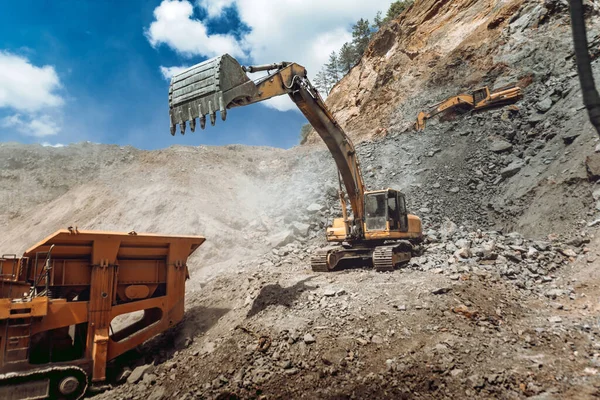 Mining industry - Heavy duty Track type excavator loading granite rock or ore quarry crushing and sorting plant