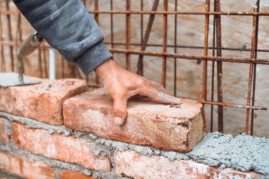 İşçi, tuğla ustası, tuğla yerleştirme ve ayarlama detayları. Dış duvar inşa eden profesyonel inşaat işçisi