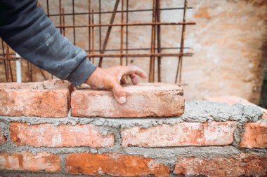 İşçi, tuğla ustası, tuğla yerleştirme ve ayarlama detaylarını kapat. Dış duvar inşa eden profesyonel işçi.