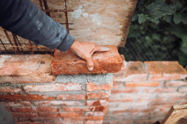 İnşaat üzerine tuğla döşeyen endüstriyel tuğla ustası otur