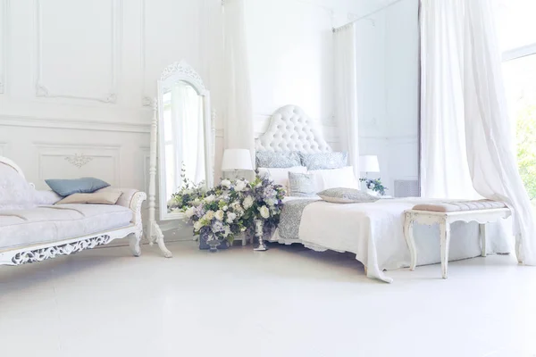 Luxury light interior design with elegant vintage furniture and floral decorations