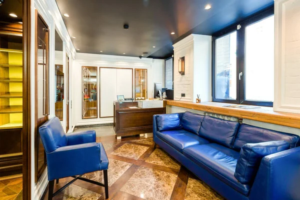 luxury barber shop interior, blue expensive furniture, wood trim, fashionable black ceiling, white robes on the backs of armchairs