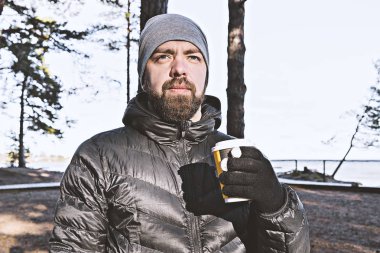 Beyaz sakallı adam ile deniz kıyısında yürüyüş kahve götürün ve gizlilik ve hava sahiptir. Geri çekilme ve anti-stres kavramı