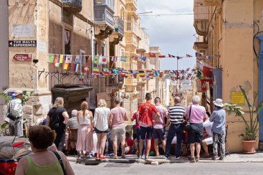 Maltese people fans watch football match on Valletta street clipart