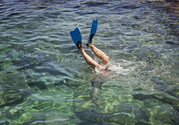 Πόδια του δύτη στα πτερύγια πάνω από την επιφάνεια της θάλασσας — Φωτογραφία Αρχείου