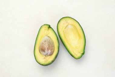 Yarı olgunlaşmış avokado beyaz masaya dilimlenmiş yakın çekim