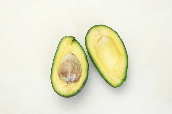 Close-up van een half gesneden van rijpe avocado op witte tafel — Stockfoto