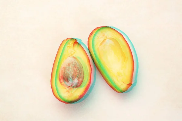 Close-up van een half gesneden van rijpe avocado op witte tafel met glitch effect — Stockfoto