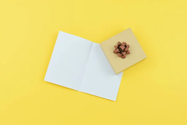 Greeting card with copy space and gift box on yellow