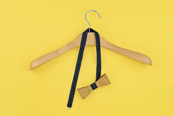 Завязанный бант, повешенный на деревянной вешалке на желтом — стоковое фото