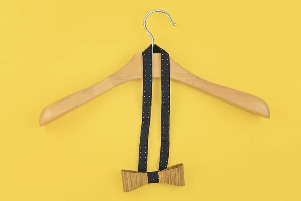 Завязанный бант, повешенный на деревянной вешалке на желтом — стоковое фото