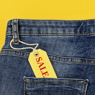 Satılık siyah Cuma ve cyber Pazartesi kavramı etiketi ile pastel sarı zemin üzerine mavi jeans indirim. Kopya alanı, düz yatıyordu, kare formatm, yakın çekim