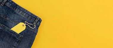 Canlı sarı arka plan üzerinde izole mavi jeans ile kavram Satılık siyah Cuma ve cyber Pazartesi indirim etiketi banner. Kopya alanı, düz yatıyordu, uzun başlık biçimi