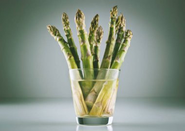 Closeup fresh ripe green asparagus in a glass. Spring vegetables and healthy diet food. Organic vegetables. Healthy eating.