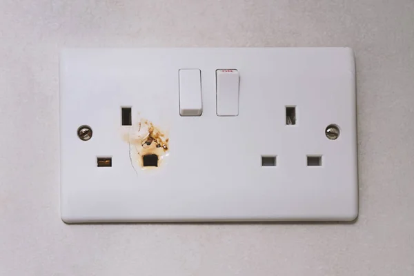 İngilizce g tipi elektrik aşırı güç fişi. Kırık güç aşırı yük anahtarı elektrik prizi. Priz, elektrik fişi, elektrik. Elektrikli cihaz aşırı yüklenmesi, yangın tehlikesi kavramı