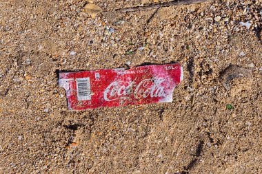 Birkirkara, Malta - 31 Aralık 2018: Plastik şişe Coca-Cola fırtına sonra kum plajındaki etiketten. Plastik kirliliği sorunu çevre kirliliği ekolojik sorun kavramı