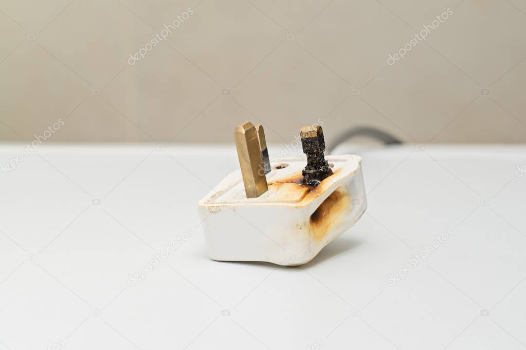 Burned 250V uk style socket and converter. Improper use of AC Power Plugs and Sockets cause of short circuit and fires at home, selective focus