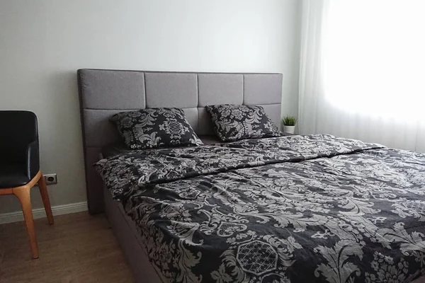 Vista del dormitorio moderno con ropa de cama oscura y pared de luz —  Fotos de Stock