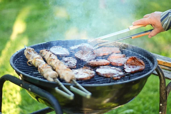 Mens manos están cocinando carne en la parrilla — Foto de Stock