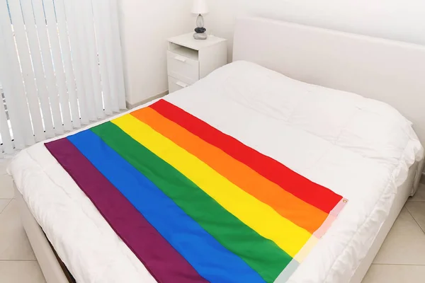 Rainbow flag comunidad LGBT en manta blanca en el dormitorio —  Fotos de Stock