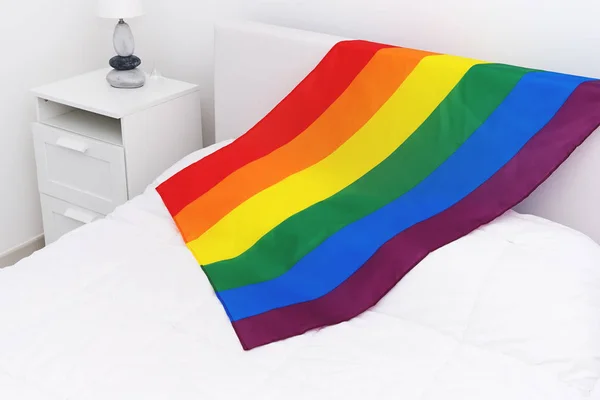 Vista superior de la comunidad LGBT bandera del arco iris en la cama blanca en el dormitorio —  Fotos de Stock