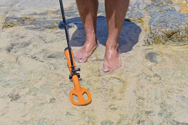 Man with metal detector is looking for lost treasure under water — Stock Photo, Image