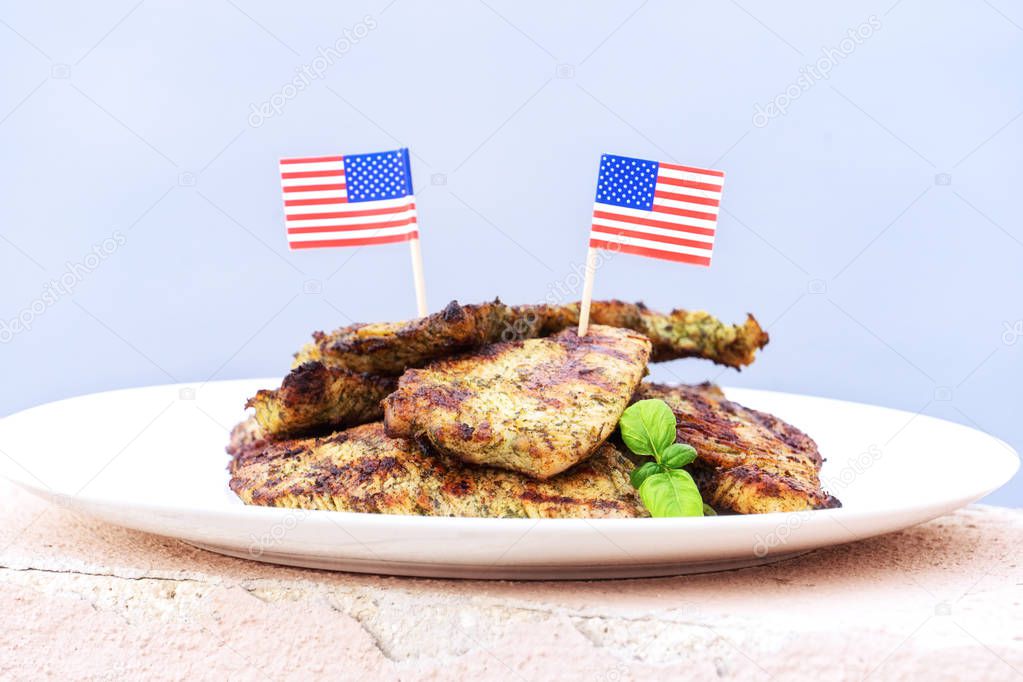 Plate with turkey steaks cooked on grill with American flags 