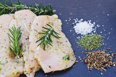 Sos tavuk fileto dilimleri ve pişirme için çeşitli baharatlar, tuz, biber ve otlar