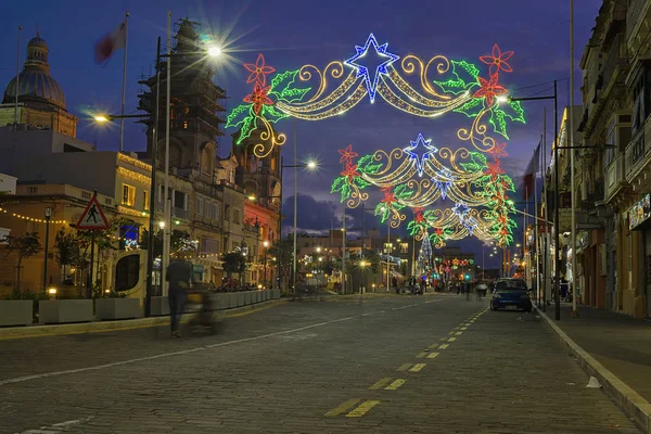 Urban street with Christmas illuminations. Xmas lights and people walking