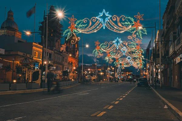 Noel aydınlatmaları ile kentsel sokak. Xmas ışıklar ve insanlar yürüyüş