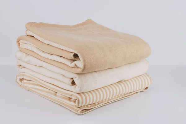 Крупным планом завернутый в сложенный природный бежевый хлопок одеяло на белом — стоковое фото