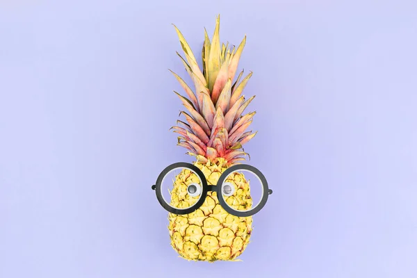 Veselý žlutý ananasový obličej s brýlemi na fialovém pozadí. — Stock fotografie