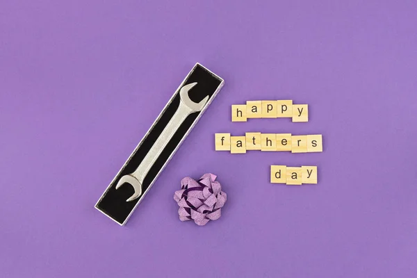 Κλειδί σε κουτί δώρου με τόξο και κείμενο ευτυχισμένη ημέρα των πατέρων στο μωβ — Φωτογραφία Αρχείου