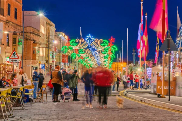Обезглавленная толпа людей во время Рождественской ярмарки старая улица города с красочными рождественскими огнями — стоковое фото